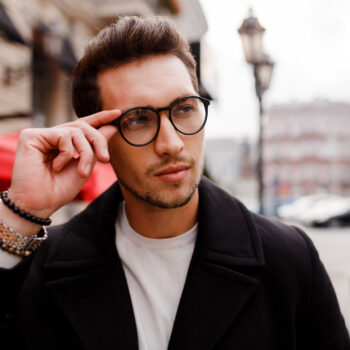 confident-young-man-full-suit-looking-away-while-standing-outdoors-european-city-wearing-eyewear-stylish-hairstylr